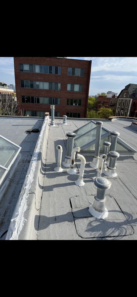 A Rooftop With Multiple Vents And Pipes